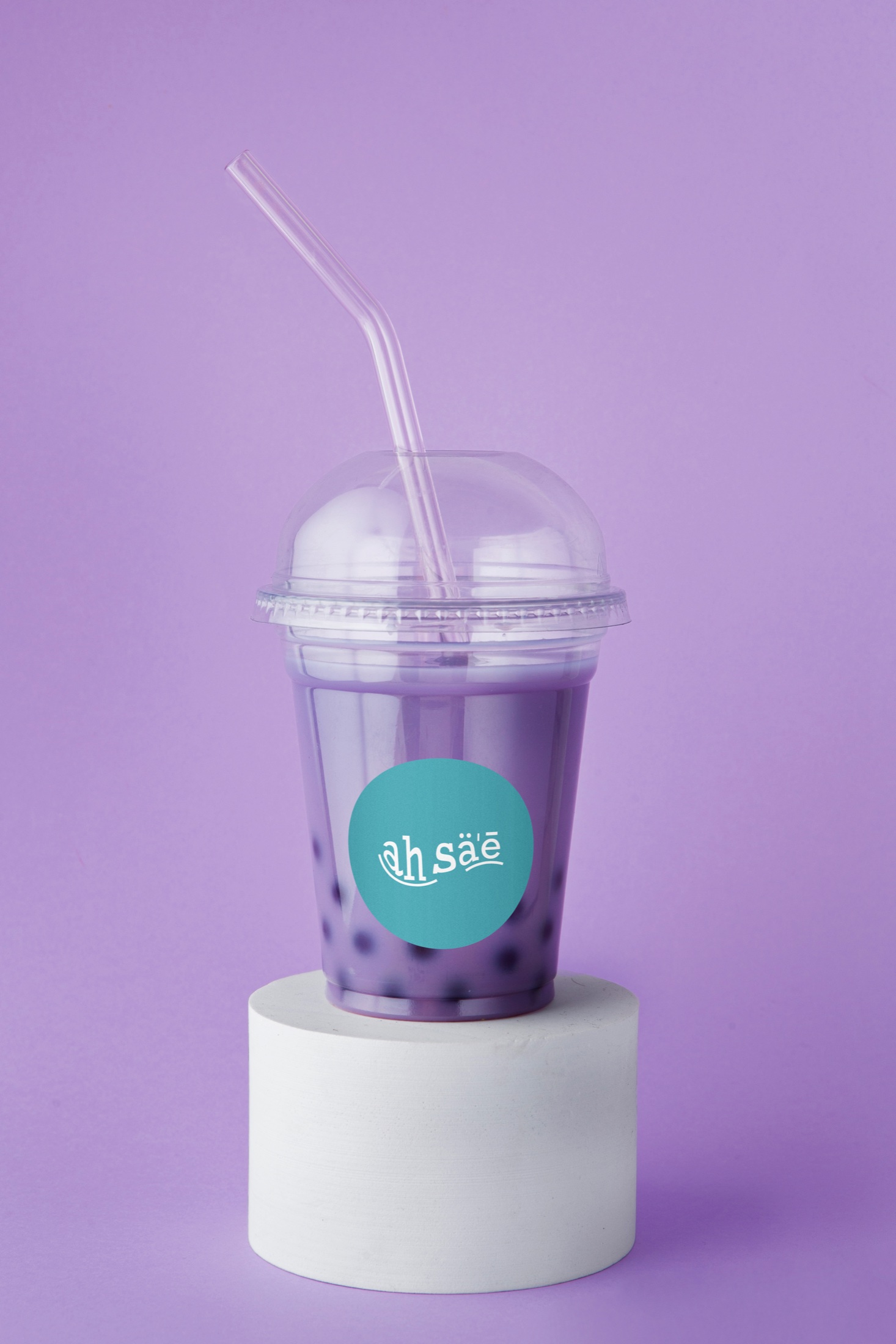 Purple drink cup carrying the teal Ah Sae logo label