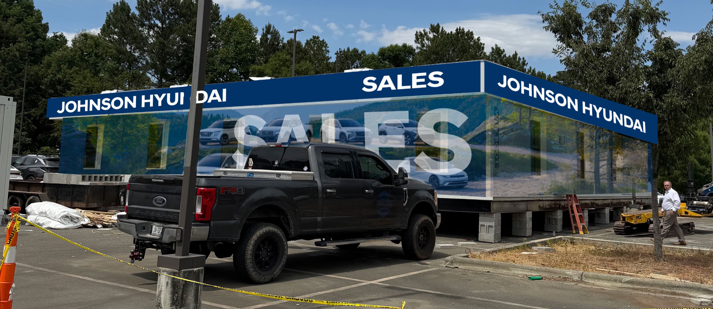 Hyundai trailer wrap being installed around windows, framing, and active site conditions