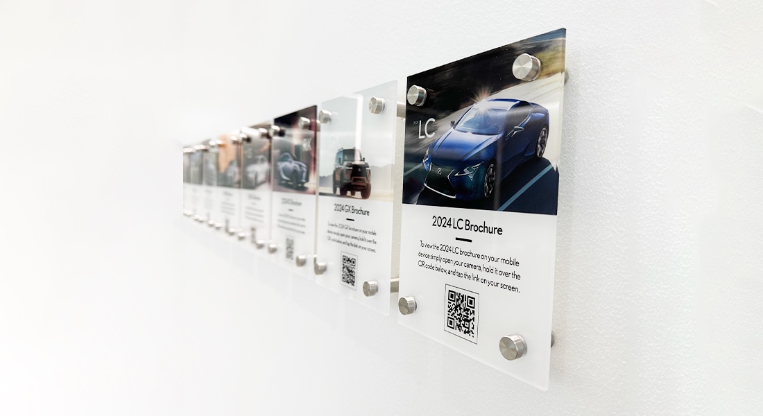 A row of Lexus QR brochure cards mounted on a showroom wall