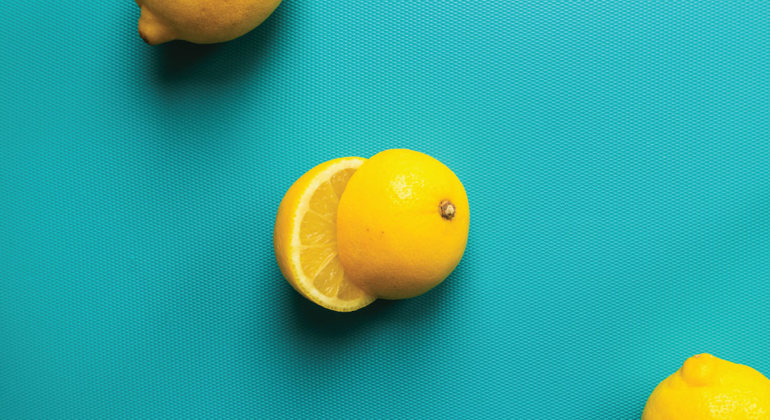 Bright yellow lemons on a saturated turquoise surface